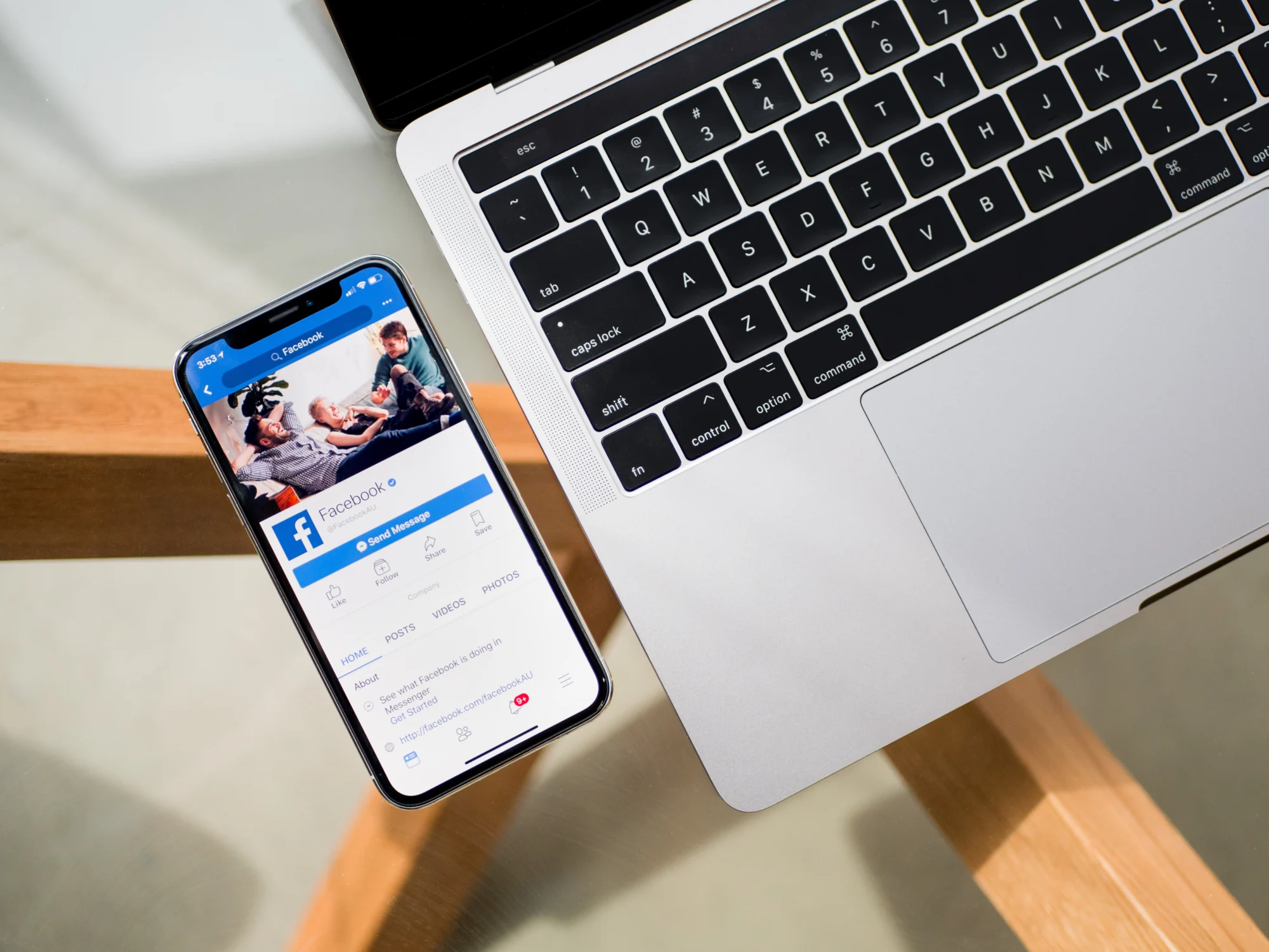 Smartphone showing a Facebook business page next to a laptop